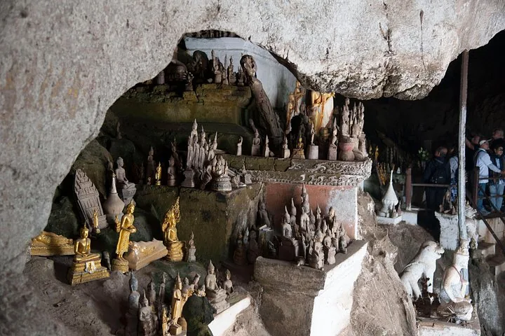 Zahlreiche kleine Buddha-Statuen, auf Felsvorsprüngen in einer Höhle angeordnet, Pak Ou-Höhlen.