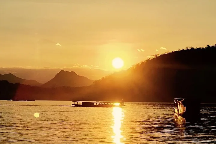 Silhouette eines Langboots, das bei goldenem Sonnenuntergang auf einem Fluss dahingleitet.